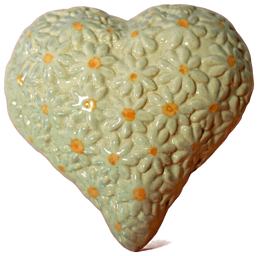 Pale cream ceramic heart covered in raised daisies with orange centres