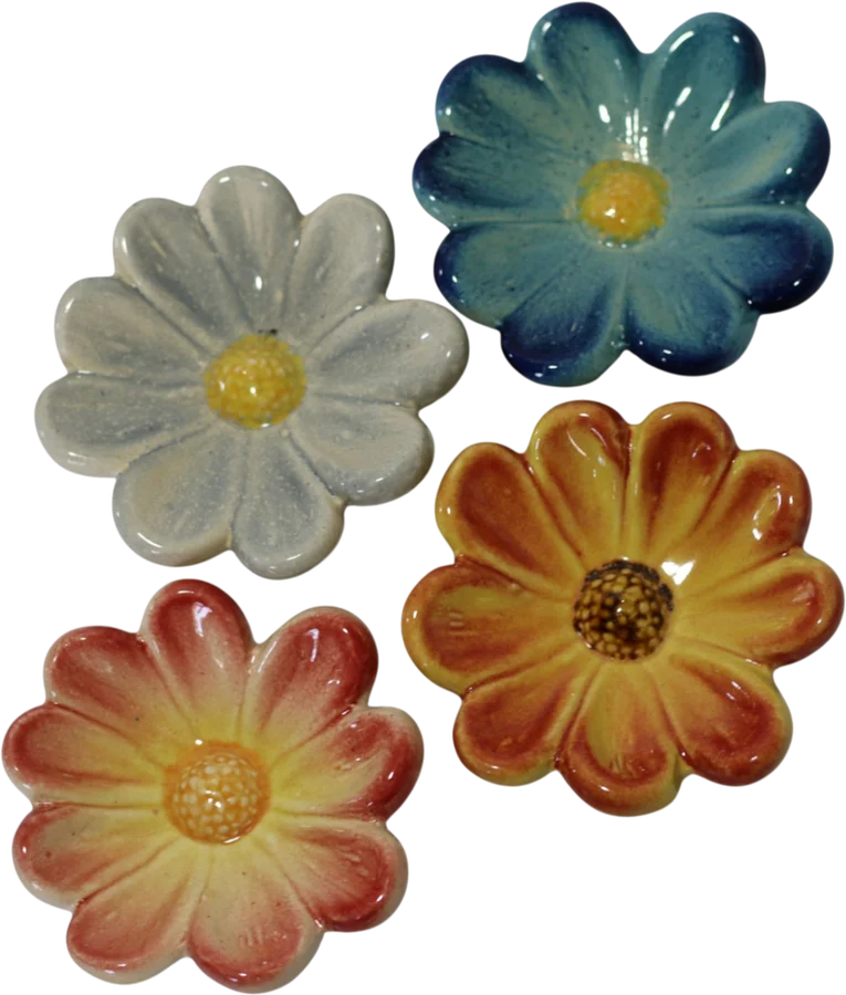 Four ceramic flowers in white, blue, orange and pink-yellow glazes, each with a yellow centre