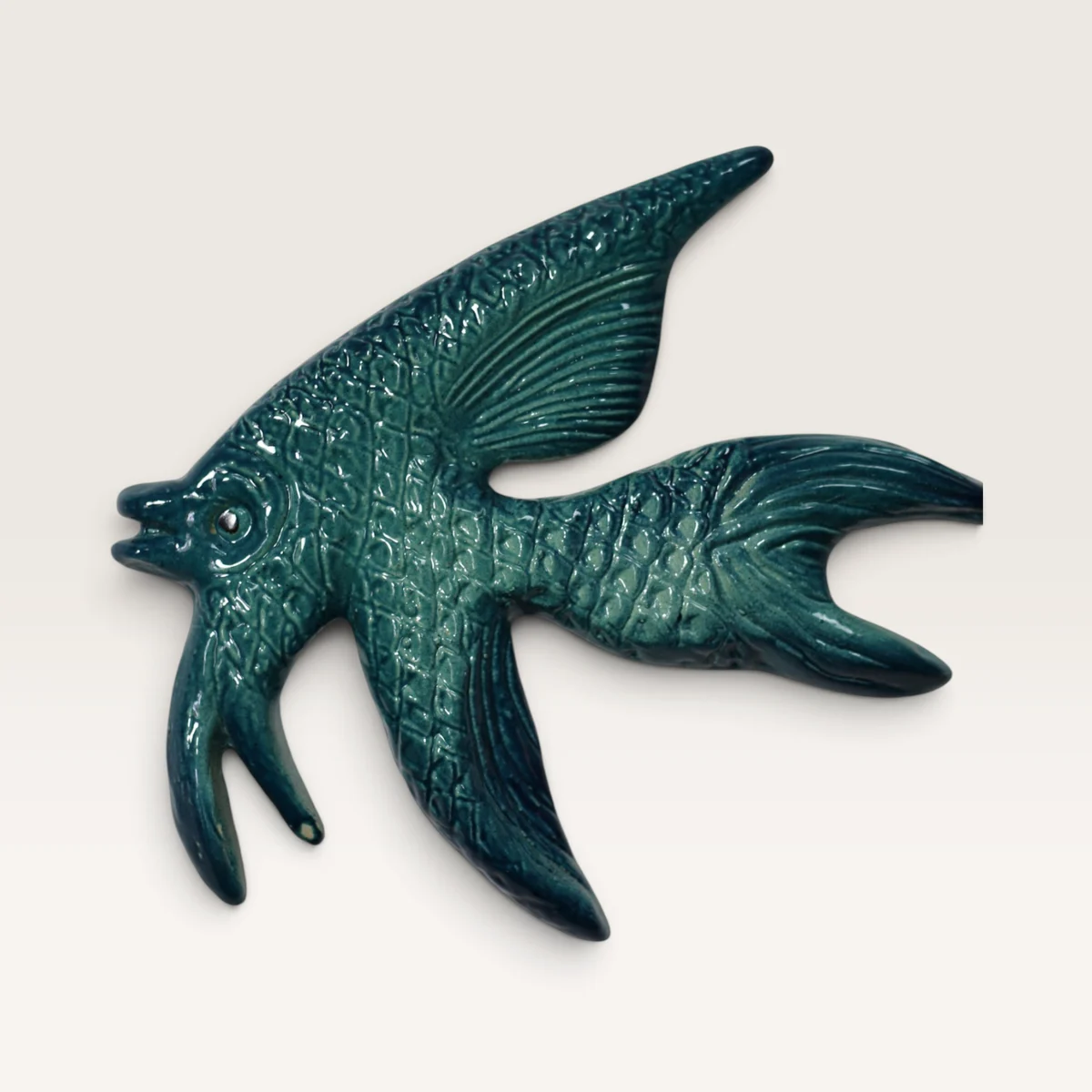 Deep teal ceramic fish with a scaled body and long, flowing fins