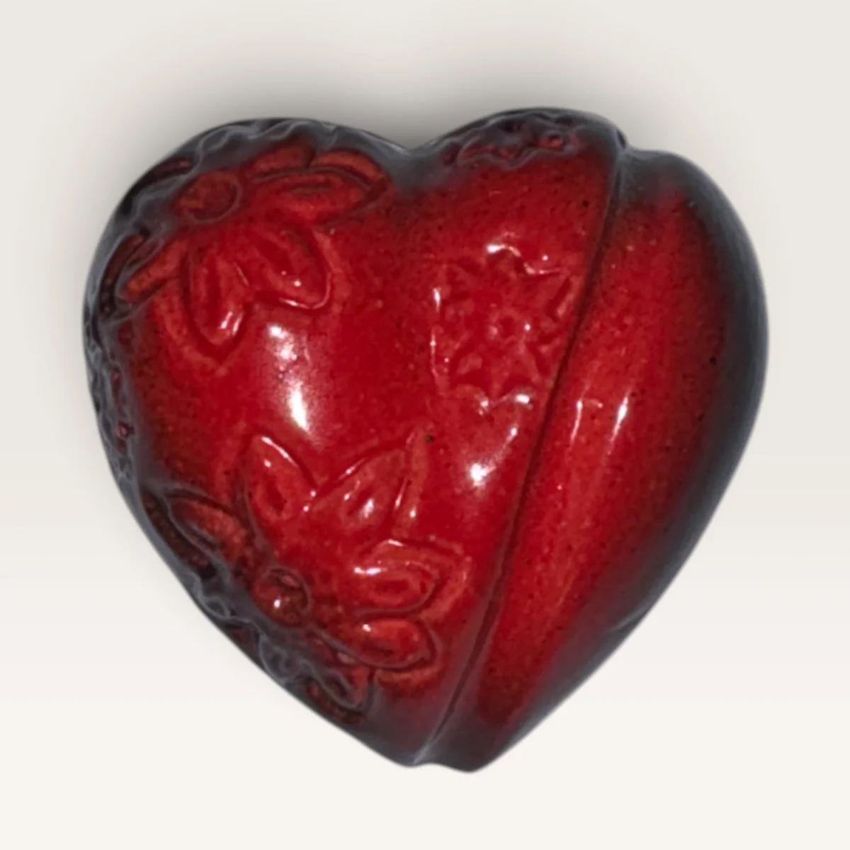 Glossy red ceramic heart with a spray of flowers pressed into one side