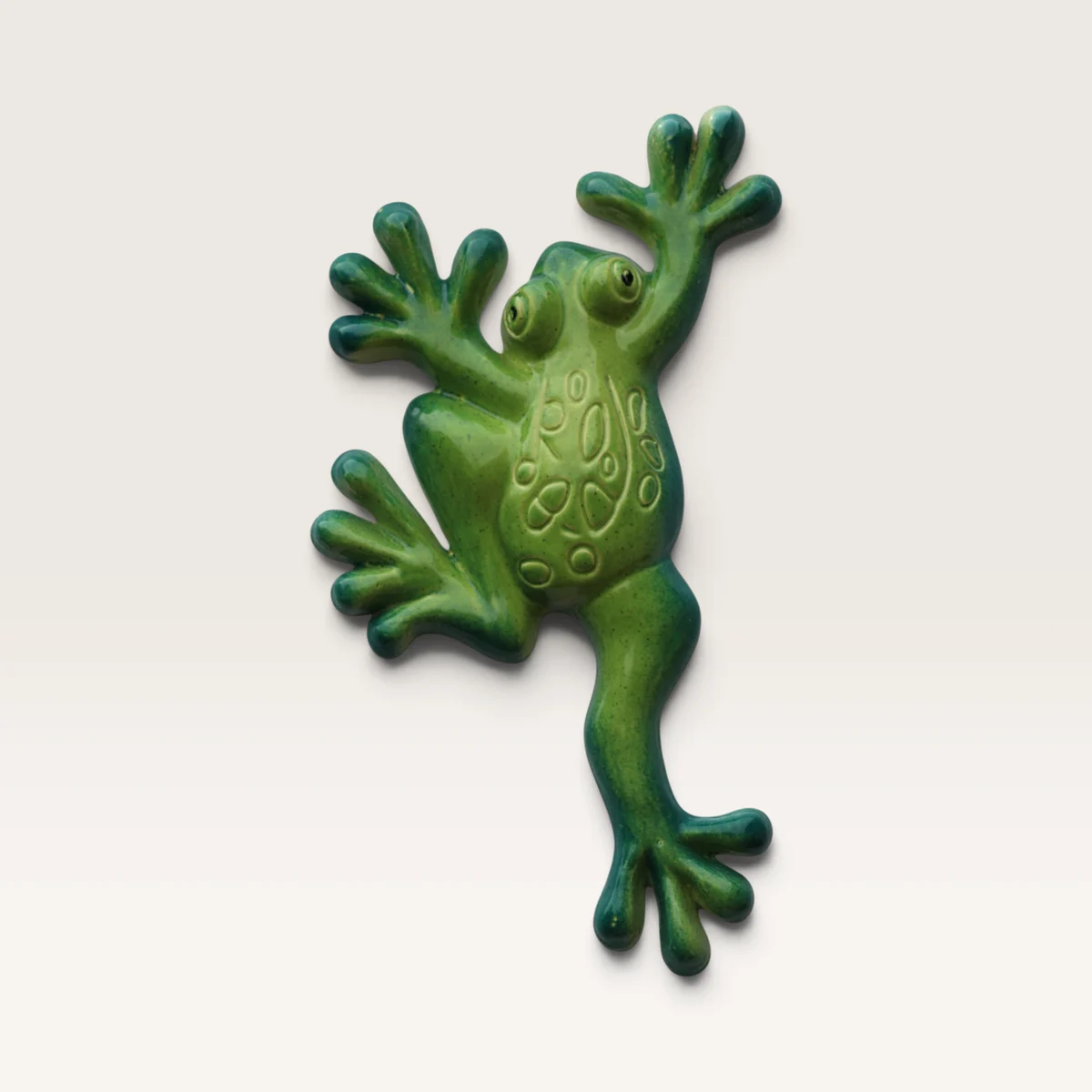 Glossy green ceramic frog in a climbing pose, legs spread wide, with a patterned back