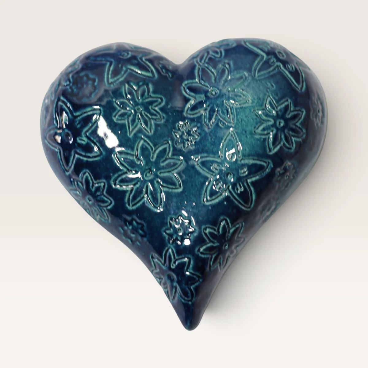 Deep teal-blue ceramic heart imprinted all over with star-shaped flowers