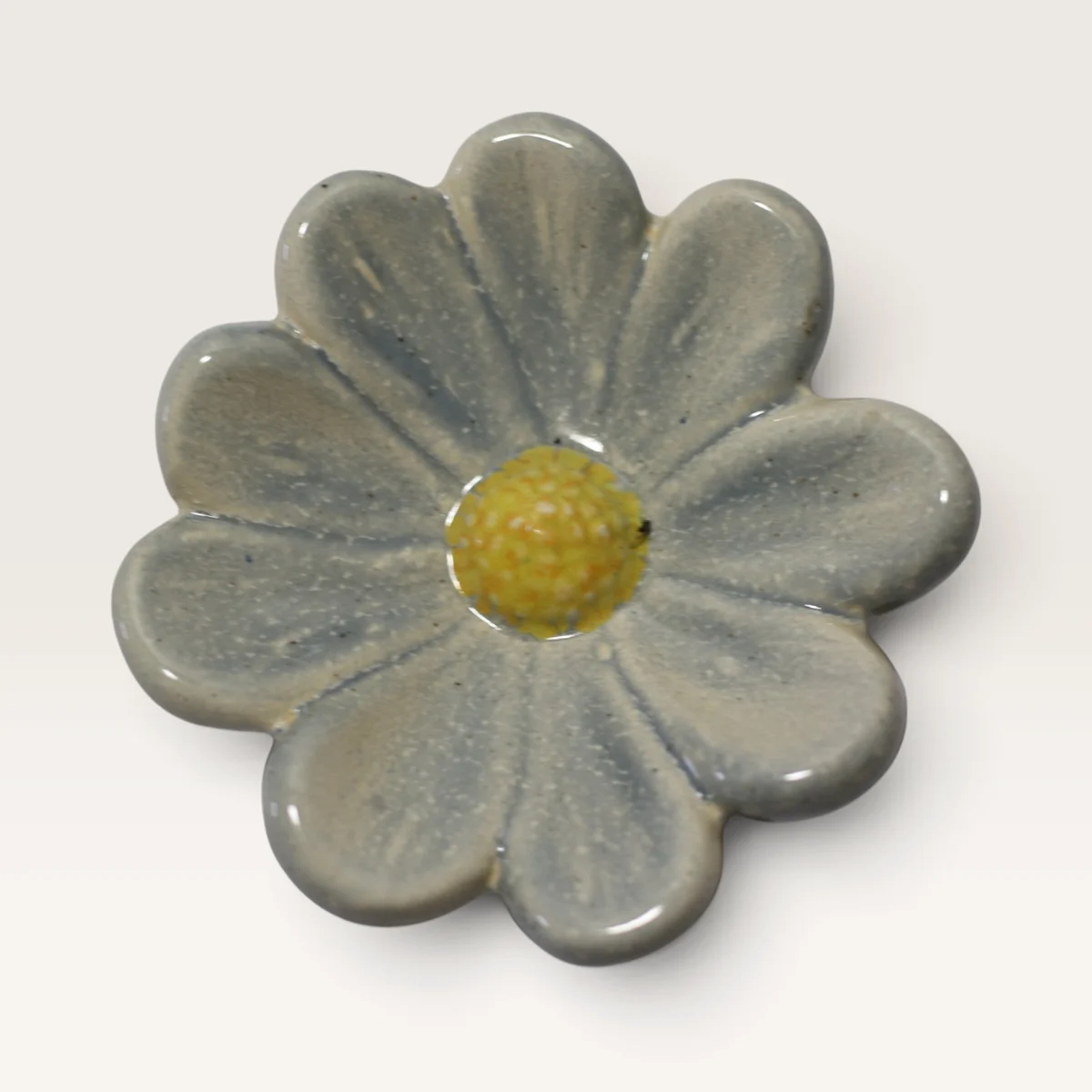 Round-petalled ceramic flower in a soft white-grey glaze with a yellow centre