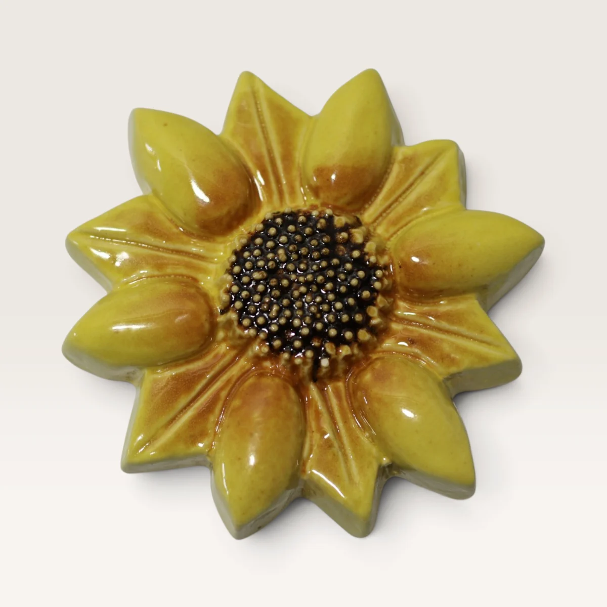 Small yellow ceramic sunflower with a dark speckled centre