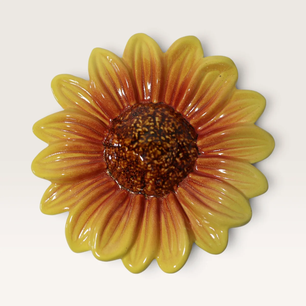 Large ceramic sunflower with yellow petals flushed orange and a dark brown centre