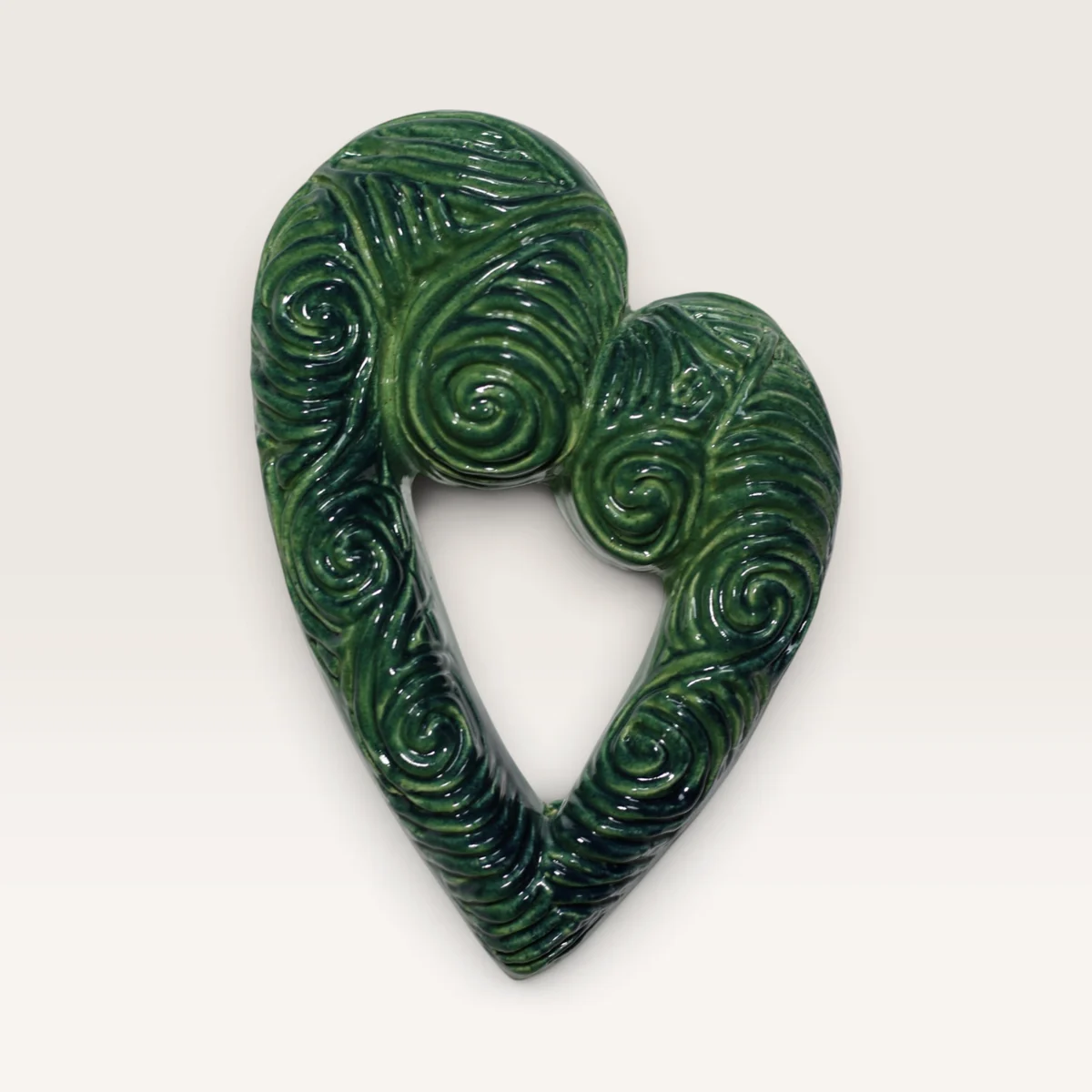 Open koru heart in a green glaze, carved all over with swirls